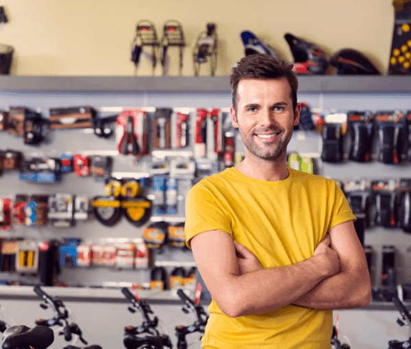 A man smiling in his business because he has Cyber Insurance for sporting goods stores