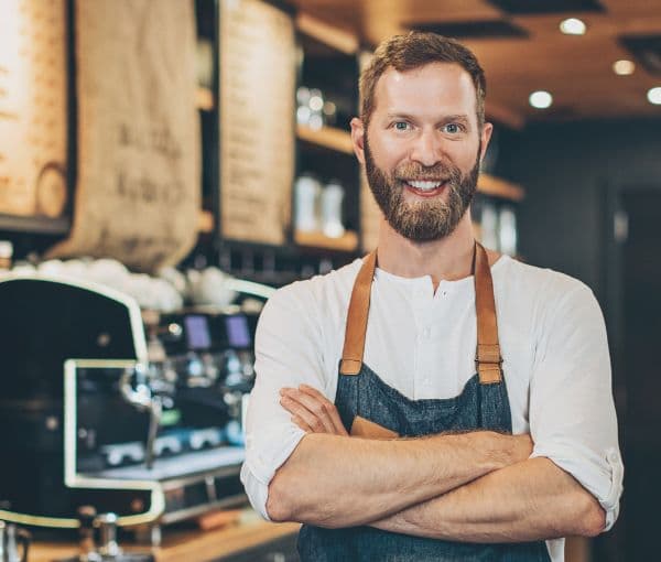 A man standing in his coffee shop with Coffee Shop Insurance