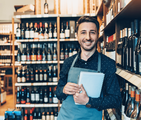 a man smiling in his wine shop with wine shop coverage